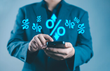 Businessman using smartphone with floating percentage icons, representing financial analytics, interest rate monitoring, digital banking, and online investment management holding