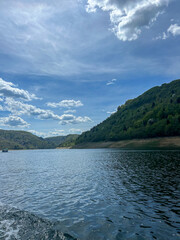 Peaceful view of Uvac Lake surrounded by forested hills and clear sky, showcasing the untouched natural beauty of Serbia’s landscape.