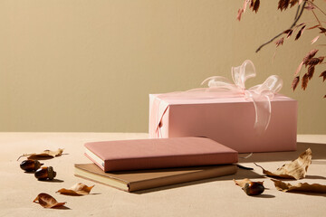 A pastel pink gift box surrounded by cinnamon and fall leaves. It combines sweetness and warmth, ideal for beauty or lifestyle branding.