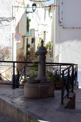an old water pump on the street, next to houses