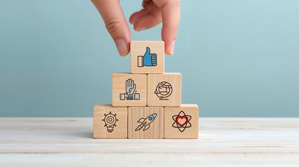 A hand is stacking wooden blocks in a pyramid formation. Business or organizational values, quality, global responsibility, justice or fairness, goal setting, innovation, and care or ethics.