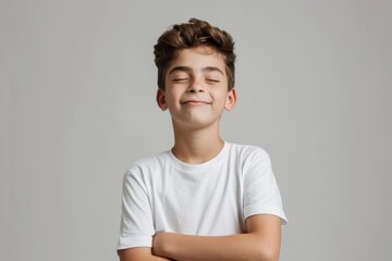 Smiling boy with crossed arms in a white t-shirt