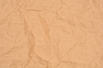 A horizontal full-frame shot captures the wrinkled and crumpled texture of plain brown kraft paper, perfect for a rustic background