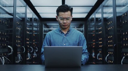 Asian man working with laptop in data server center - Engineer, IT and technology concept - Model by AI generative
 - Powered by Adobe