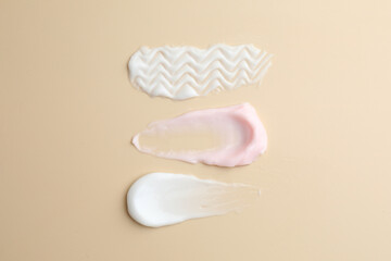Samples of different cosmetic products on beige background, flat lay