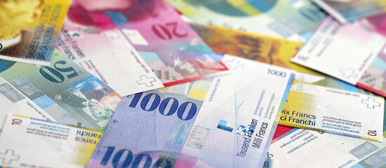 Swiss franc banknotes. The current francs money bills lies on table in big amount. The concept of business and investment in Switzerland