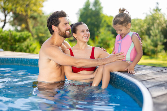 Cute family spending their day at the swimming pool