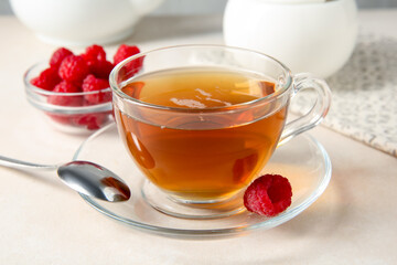 Delicious tea and raspberries on white table, closeup