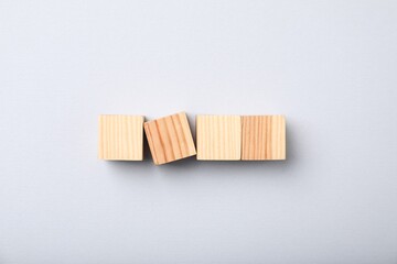 Wooden cubes on light background, top view