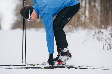 Male skier adjusting cross country ski boot