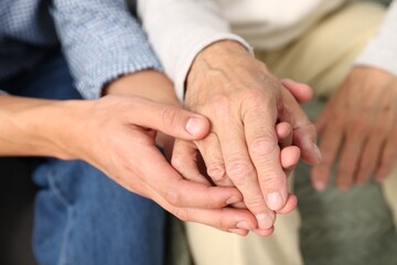 Fototapeta premium Father and son holding hands at home, closeup