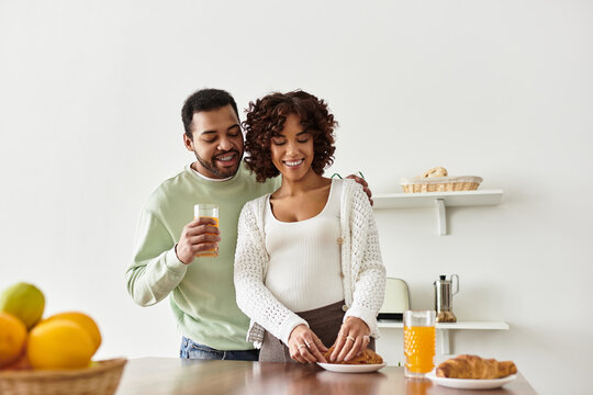 Joyful African American couple sharing breakfast and preparing for new life together
