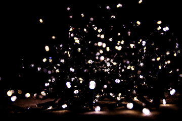 Abstract bokeh lights on a dark background. Christmas magical light, overlay or lens flare effect