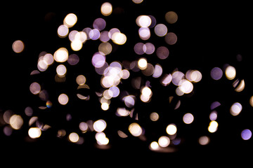 Abstract bokeh lights on a dark background. Christmas magical light, overlay or lens flare effect