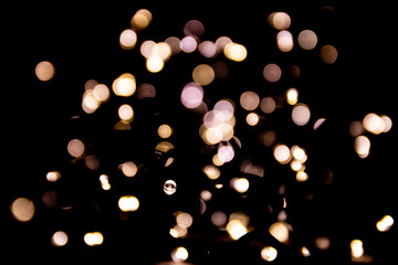 Abstract bokeh lights on a dark background. Christmas magical light, overlay or lens flare effect
