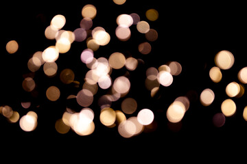 Abstract bokeh lights on a dark background. Christmas magical light, overlay or lens flare effect
