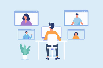 Man wearing headphones attending a video conference call with colleagues on multiple screens