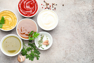 Different sauces, spices and herbs on light table, flat lay. Space for text