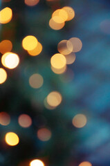 Golden bokeh lights on a dark background. Christmas magical light background, overlay or lens flare effect