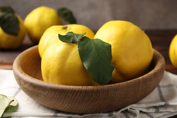 Fresh ripe quinces with leaves on table, closeup