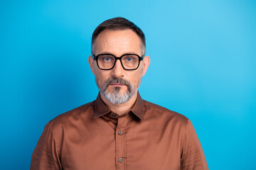 Fototapeta premium Confident mature business professional wearing brown shirt and glasses against blue background for corporate headshot and office lifestyle