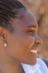 portrait single young african woman smiling, braids, dreadlocks hairstyle, white blouse