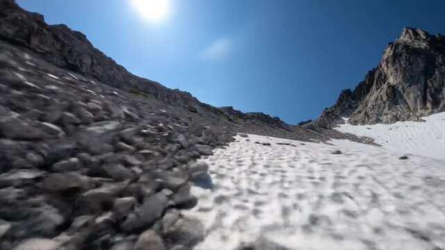 Rugged mountain landscape under clear blue sky with snow and rocks