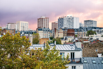 Urban landscape of Paris rooftops and buildings under a pastel sunset sky. Calm atmosphere with city textures and autumn colors.