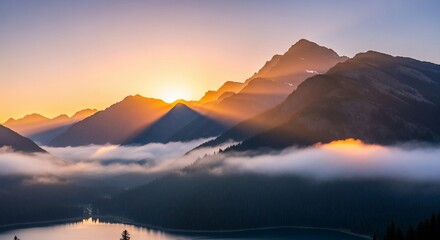 Sunrise casting golden rays over misty mountains and a serene lake.