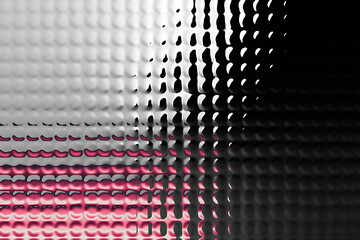 Abstract textured surface with pink highlights and varying light and shadow effects