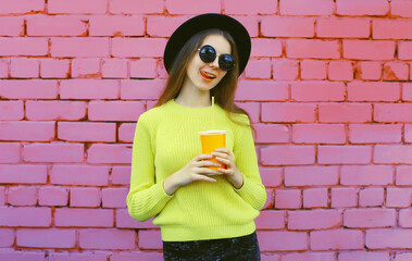 happy stylish young woman, trendy modern girl with juice drink cup posing on pink wall