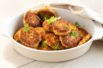 Appetizing juicy cutlets in ceramic dishes on a light background