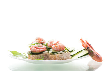 Small canapes with shrimps, salad and cucumbers on a white background