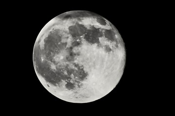 Bright full moon with visible craters in the dark night sky