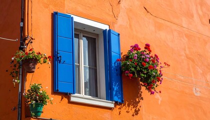 Exterior shot featuring an orange stucco wall, blue window shutters, and vibrant flower baskets