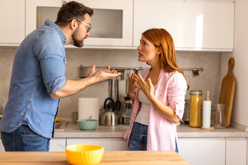 couple is having argument in the kitchen during breakfast. The scene reflects a moment of frustration and conflict, with both individuals visibly upset in a home setting. disagreement in everyday life