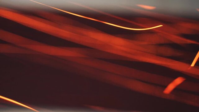 Abstract orange and red light patterns with curved reflections. Suggests flame movement and refracted energy.