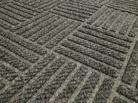 Close-Up of Patterned Carpet Floor Tiles. Textured grey carpet tiles with geometric patterns arranged in alternating directions, ideal for commercial or office interior flooring