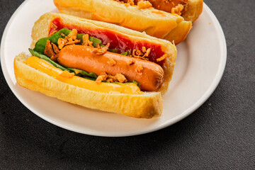 Hotdog fried onions, sausage, bun, sauce fast food tasty snack fresh delicious gourmet food background on the table rustic top view copy space