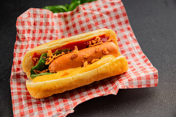 Hotdog fried onions, sausage, bun, sauce fast food tasty snack fresh delicious gourmet food background on the table rustic top view copy space