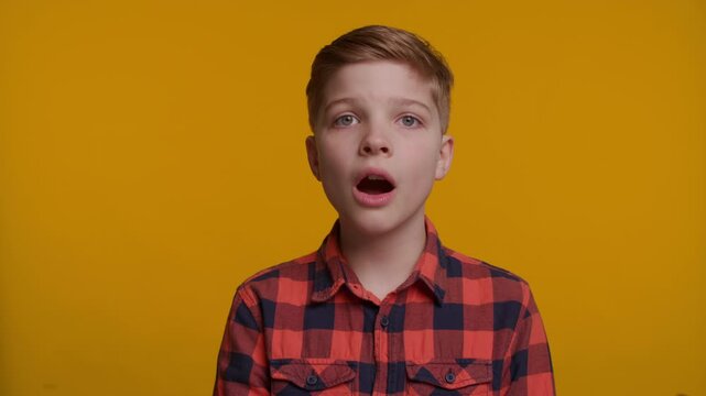 Shocked Boy with Mouth Open on Yellow Background