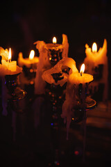 Burning candles in metal candlestick with melted wax
