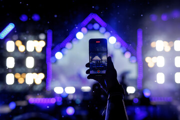 Recording concert on smartphone with stage lights in background