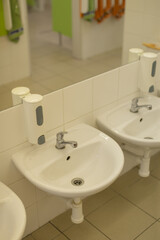 Clean toddler bathroom space, Childfocused wash station featuring reflective mirrors and sanitary accessories