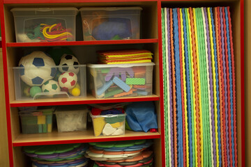 Vivid toy storage, Vibrant storage units with toys and mats create lively classroom corner for preschool play