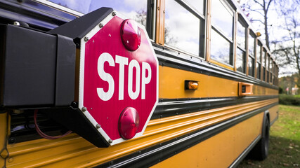 Yellow school bus with a prominent stop sign, parked in a safe area