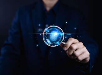 Businessman hand holding magnifying glass with glowing digital fingerprint and Concept of cybersecurity, identity verification, data protection, and technology innovation in business.