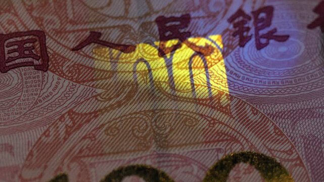 Close-up of a Chinese 100 Yuan banknote under UV light, revealing the fluorescent security feature with the glowing number 100.