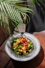 Fresh salad with grilled chicken and toppings in a cozy dining setting