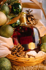 Festive holiday basket with sparkling ornaments and a bottle of liquor